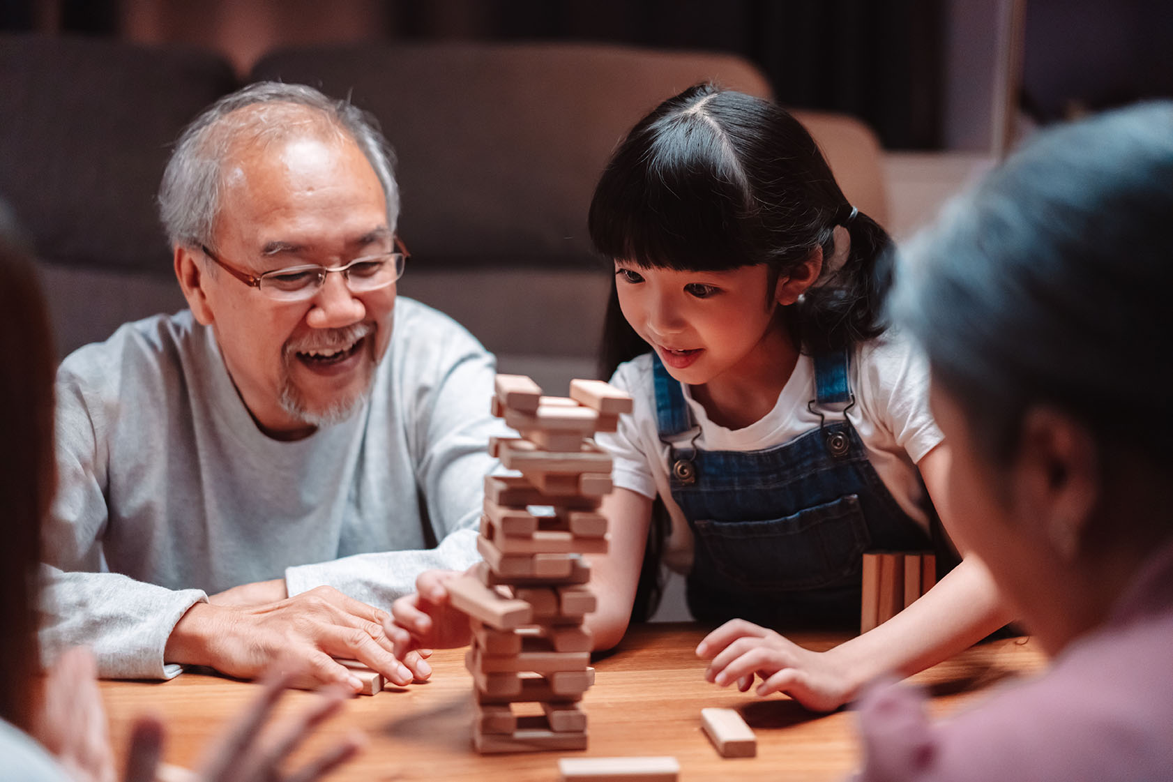 Happy family playing jenga in a warm home
